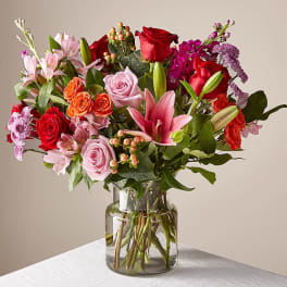 Mixed bouquet of roses, lilies, and alstroemeria in a glass vase
