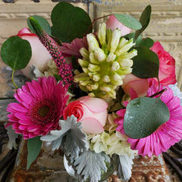 Bouquet of pink roses and gerbera daisies in a glass vase