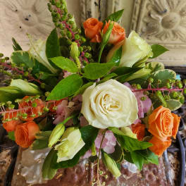 Bouquet of white and orange roses with green berries and pink flowers