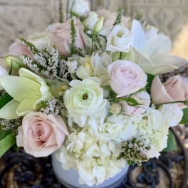 Blush and white bouquet with roses, lilies, and hydrangea in a vase