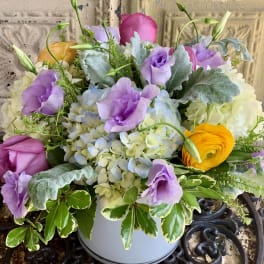 Pastel bouquet of roses, hydrangeas, and lisianthus in a white container