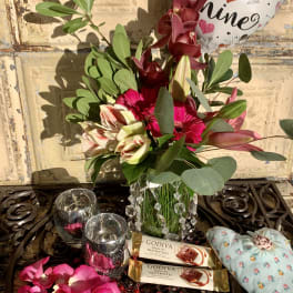 Bouquet with pink and burgundy flowers, chocolates, and a heart balloon