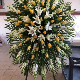 Large standing floral spray with white lilies and yellow roses