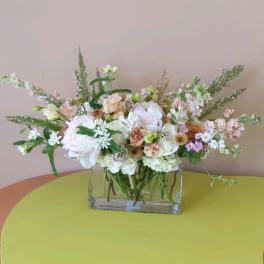 Pastel mixed flower arrangement in a clear rectangular vase