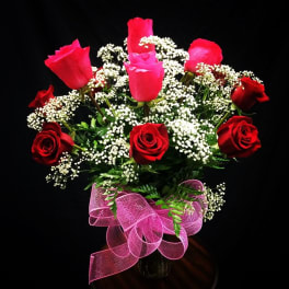 Bouquet of red and pink roses with baby's breath in a vase