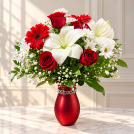Red roses, white lilies, and white daisies in a red vase
