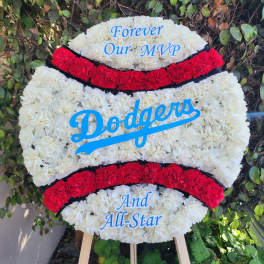 Dodgers-themed floral tribute on an easel with white and red flowers