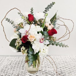 Bouquet of red and white flowers in a clear glass vase