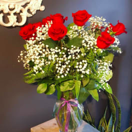 Red roses and baby's breath in a clear glass vase