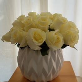 Cream rose bouquet in a white textured vase
