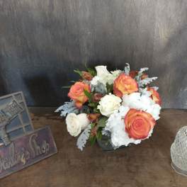 Bouquet of orange and white roses with white hydrangeas in a vase