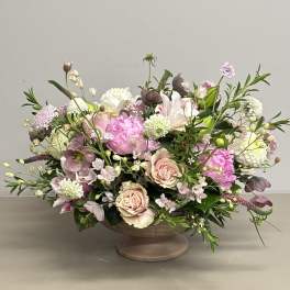 Mixed pink and white floral arrangement in a low pedestal bowl