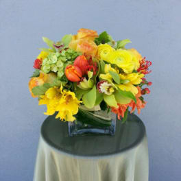 Bright mixed bouquet in a square glass vase