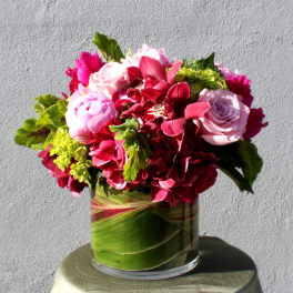 Pink and red floral arrangement in a glass vase