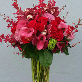 Red and pink floral arrangement in a clear glass vase