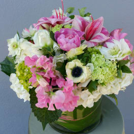 Pink and white mixed bouquet in a green glass vase