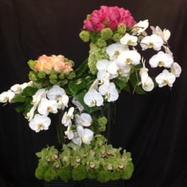 Pink roses and white orchids in a tall floral arrangement