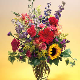 Mixed bouquet of colorful flowers in a clear glass vase