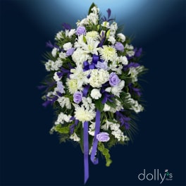 White and lavender floral spray with purple ribbon on a dark blue background