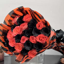 Bouquet of red and black roses wrapped in orange-and-black paper