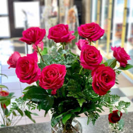 Hot pink roses arranged in a clear glass vase