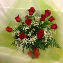 Bouquet of red roses with white filler flowers in a glass vase