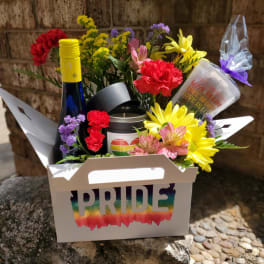 Rainbow flower gift box with a Pride label, bottle, candle, and cup