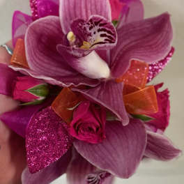 Pink orchid and rose corsage with orange ribbon accents