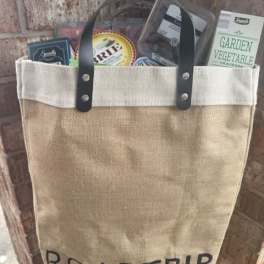 Canvas tote bag filled with packaged food items and a garden vegetable cracker box