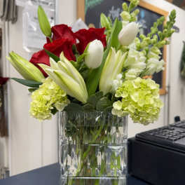 Red roses and white tulips in a clear glass vase