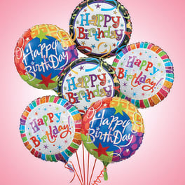 Cluster of colorful Happy Birthday balloons on a pink background