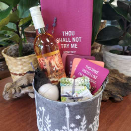 Gift basket with a wine bottle, cards, and small bath items
