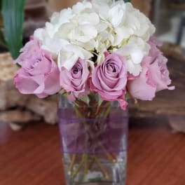 Pink roses and white hydrangeas in a clear square vase
