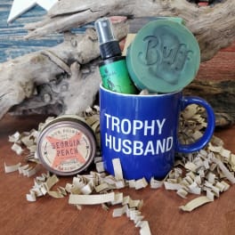 Gift mug with candle and soap on shredded paper filler