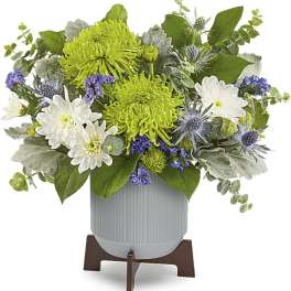 White and green floral arrangement in a gray vase