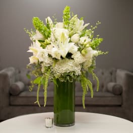 White floral arrangement in a tall green vase