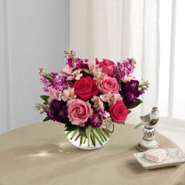 Pink and purple rose bouquet in a clear glass vase