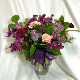 Bouquet of purple and pink flowers with a purple ribbon