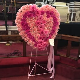 Heart-shaped pink floral standing tribute on an easel