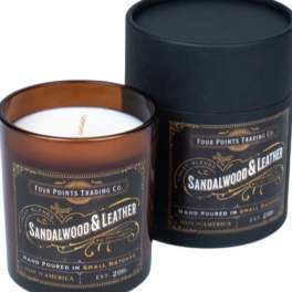 Two sandalwood and leather candles in dark glass jars