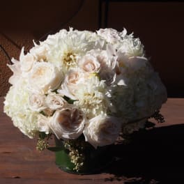 White roses and hydrangeas arranged in a green vase