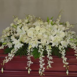 White floral casket spray with lilies and roses