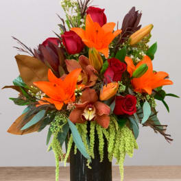 Bouquet of orange lilies and red roses in a black vase