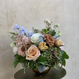Mixed pastel bouquet in a low gold bowl vase