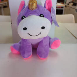 Purple unicorn plush toy with a gold horn and pink accents
