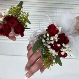Red rose wrist corsages with white baby's breath and tulle ribbon