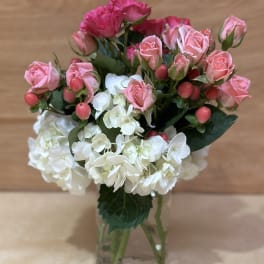 Pink roses and white hydrangeas in a clear glass vase