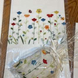 Embroidered floral napkins with a small matching pouch in clear wrapping