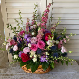 Basket arrangement of pink, purple, white, and red flowers