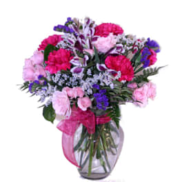 Pink and purple mixed bouquet in a clear glass vase with a ribbon